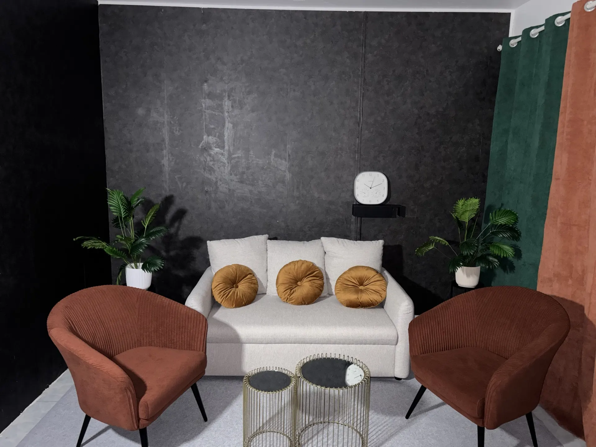 Le plateau du Studio DTV prêt à tourner : canapé clair, deux fauteuils, tables basses dorées, plantes et rideaux verts